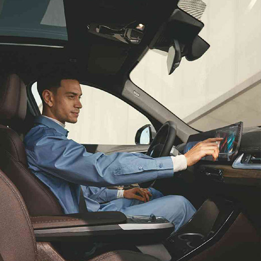 Connected Charging im Fahrzeug Mann bedient BMW Curved Display