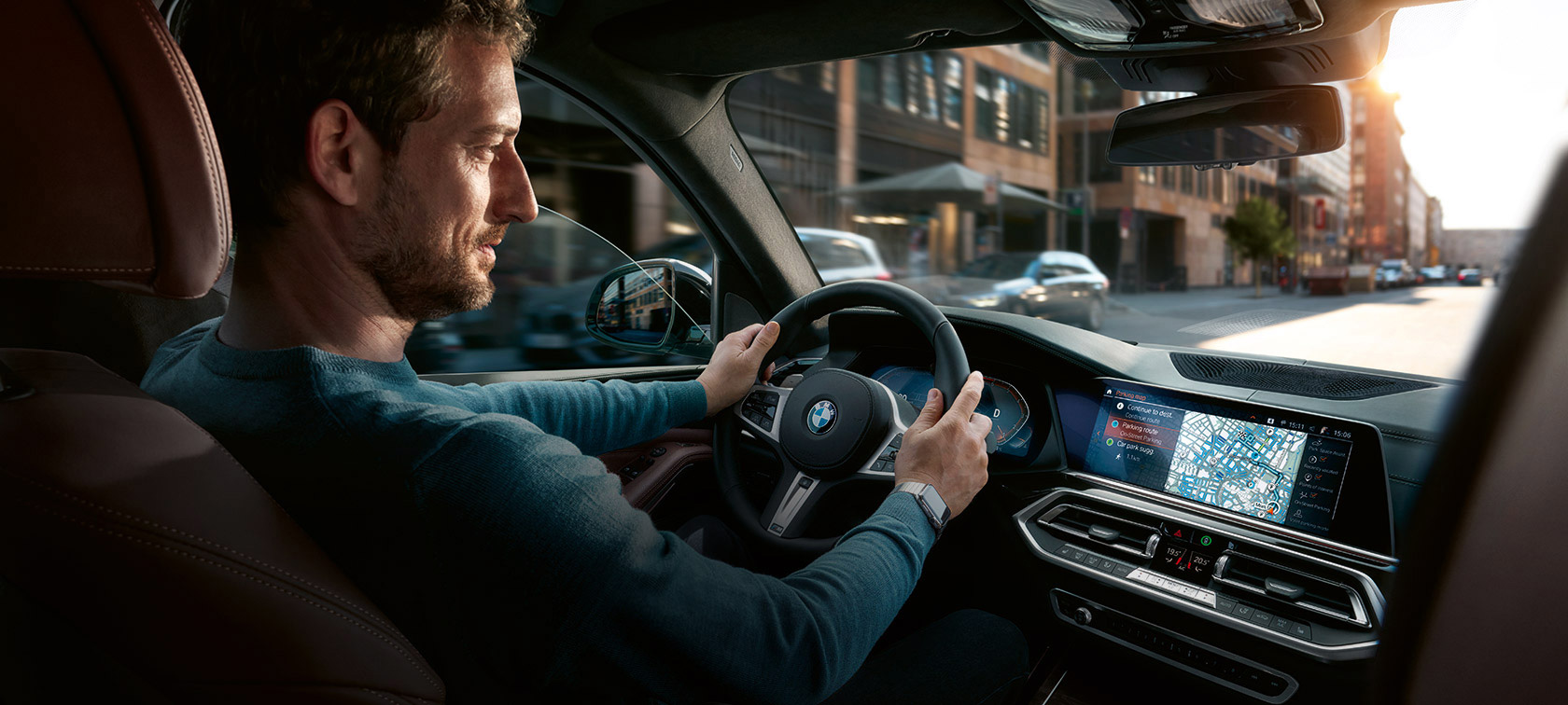 BMW Maps Navigation Mann fährt in BMW mit BMW Maps Navigation im Control Display