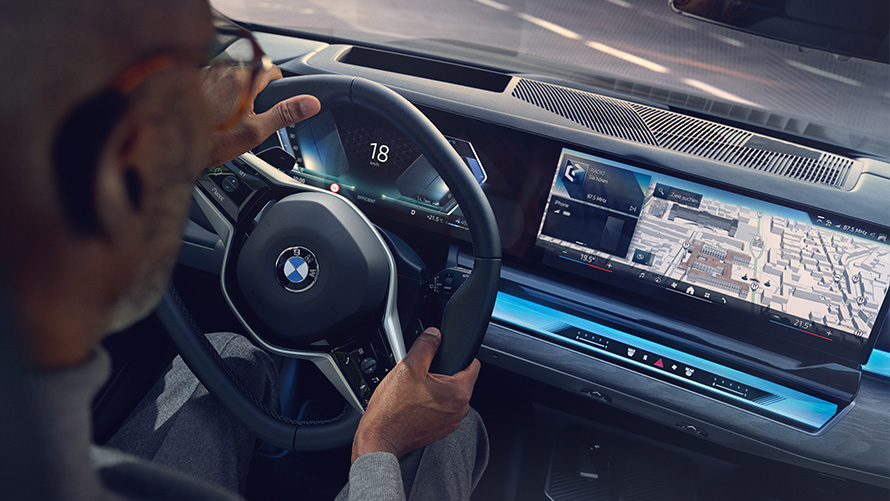 BMW Interieur Mann schaut auf Display mit Operating System 8.5 BMW Interieur Mann schaut auf BMW Maps auf Display mit Operating System 8.5