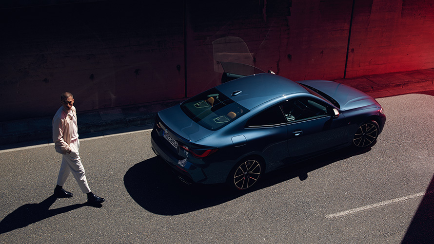 Remote Software Upgrade Mann hinter dem BMW Heck Straße überquerend Mann hinter dem BMW Heck Straße überquerend