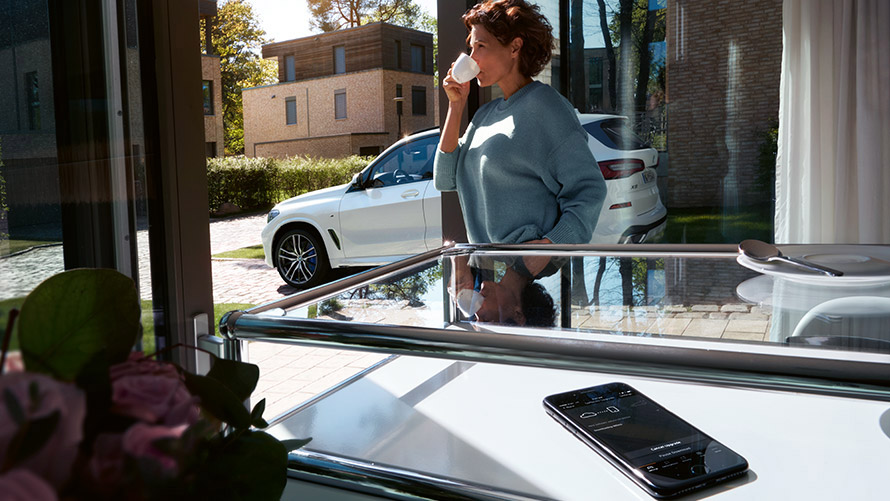 Remote Software Upgrade Frau genießt Kaffee zu Hause während Remote Software Upgrade auf Smartphone läuft