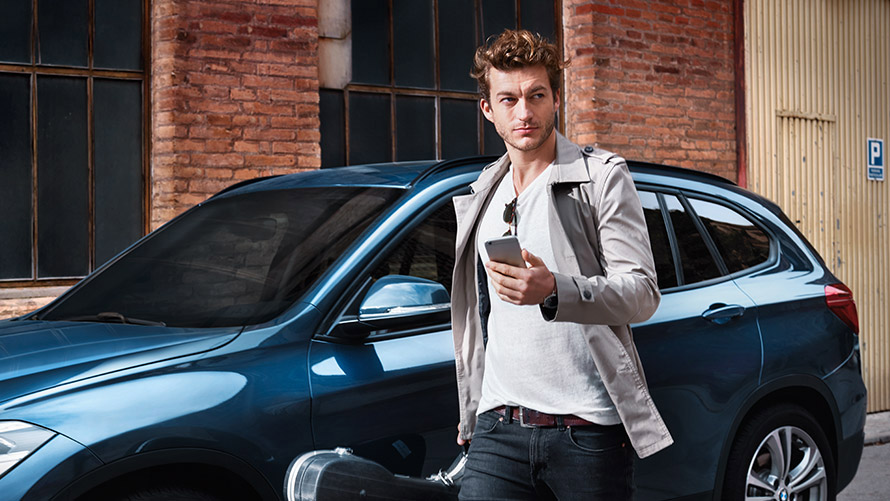 Navigate Door-to-Door Junger Mann geht durch die Stadt und nutzt Navigate Door-to-Door auf seinem Smartphone