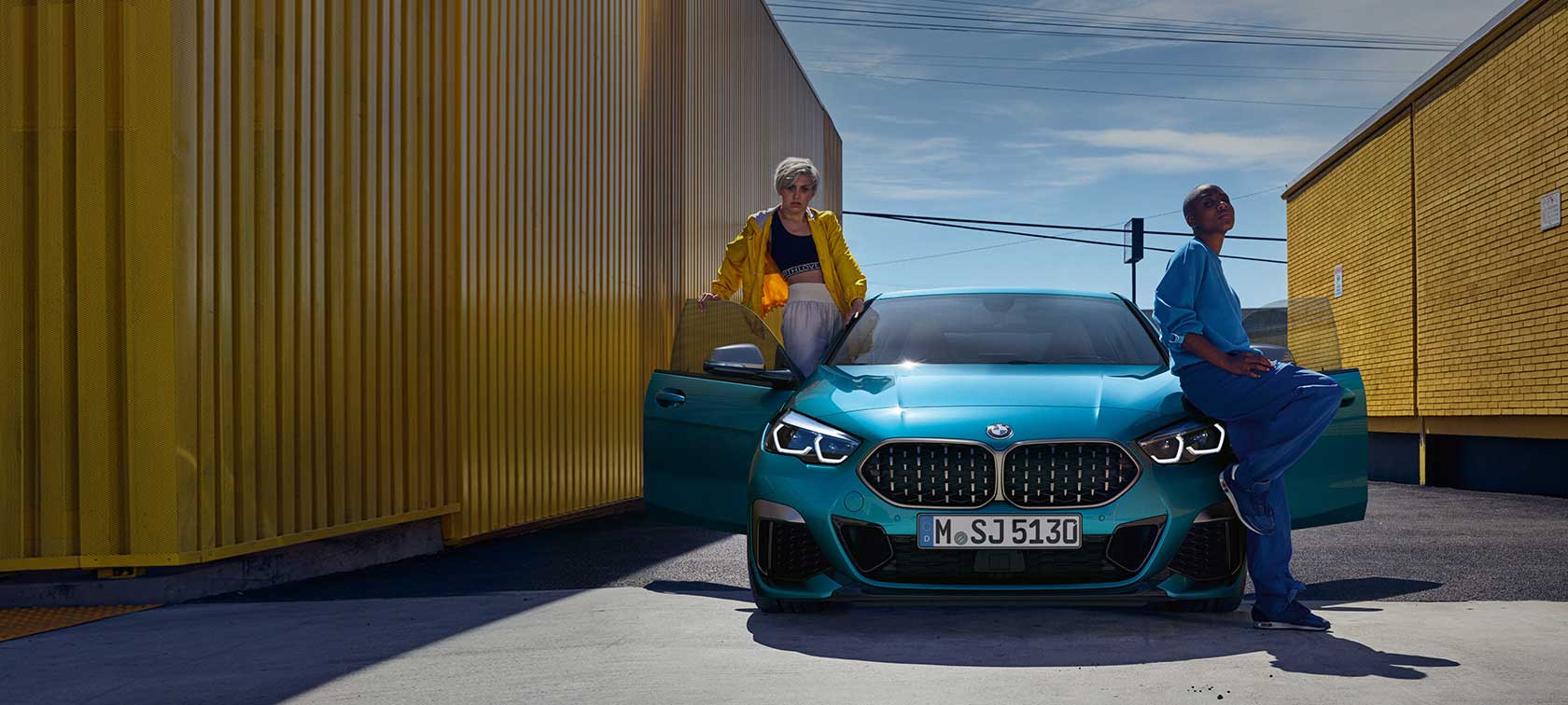 BMW 2er Gran Coupé F44, Frontansicht BMW 2er Gran Coupé F44 Snapper Rocks Blau metallic, Frontansicht mit geöffneten Türen und zwei Personen am Fahrzeug