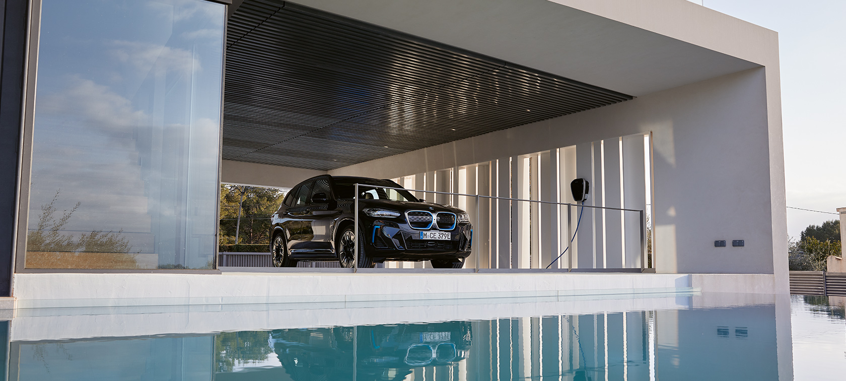 BMW i3s I01 2018 Fluid Black mit Akzent BMW i Blau Dreiviertel-Heckansicht vor Garage mit BMW Wallbox