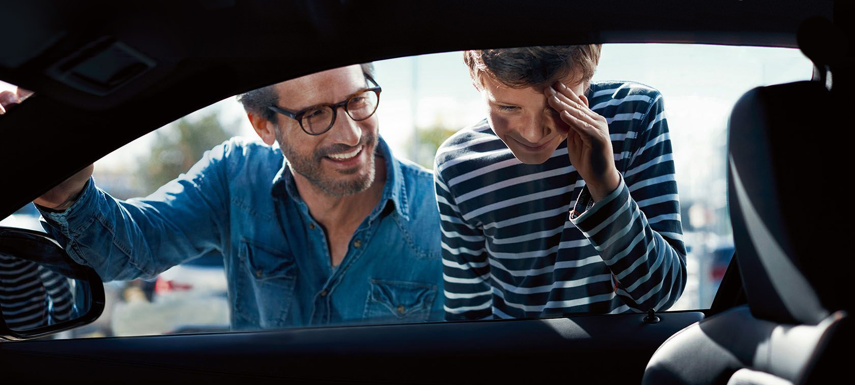 BMW Mann und Kind schauen von außen in die Fahrerkabine BMW Mann und Kind schauen von außen in die Fahrerkabine
